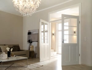 Helles Wohnzimmer mit Doppelflügeltür, moderner Einrichtung und Kronleuchter.